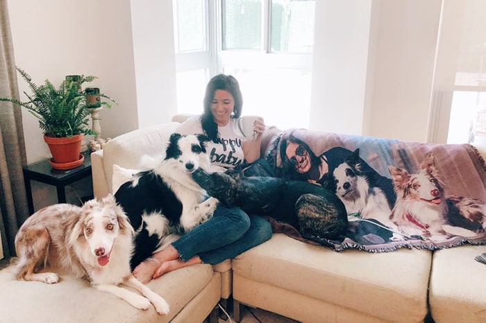Young woman lounging with dogs on photo blanket