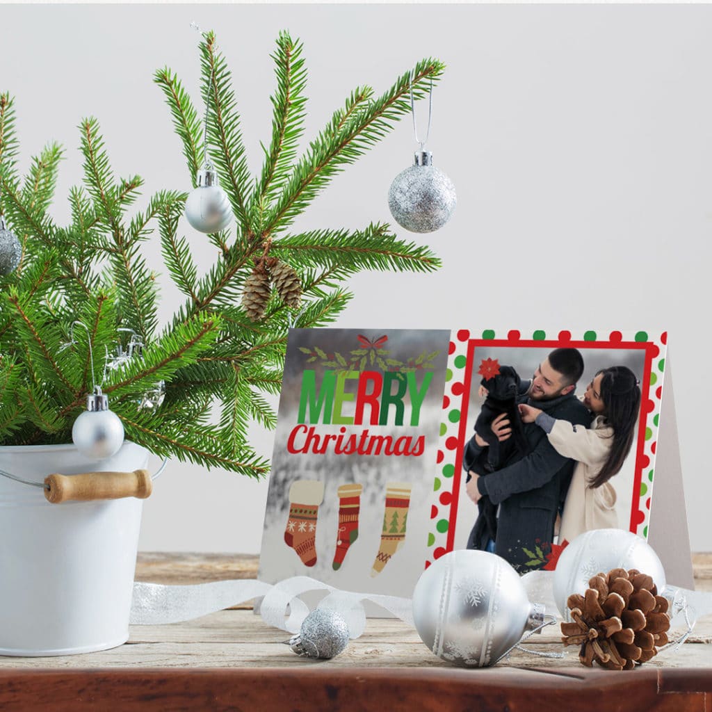 propped up greeting card featuring dog and owners, surrounded by christmas decoration