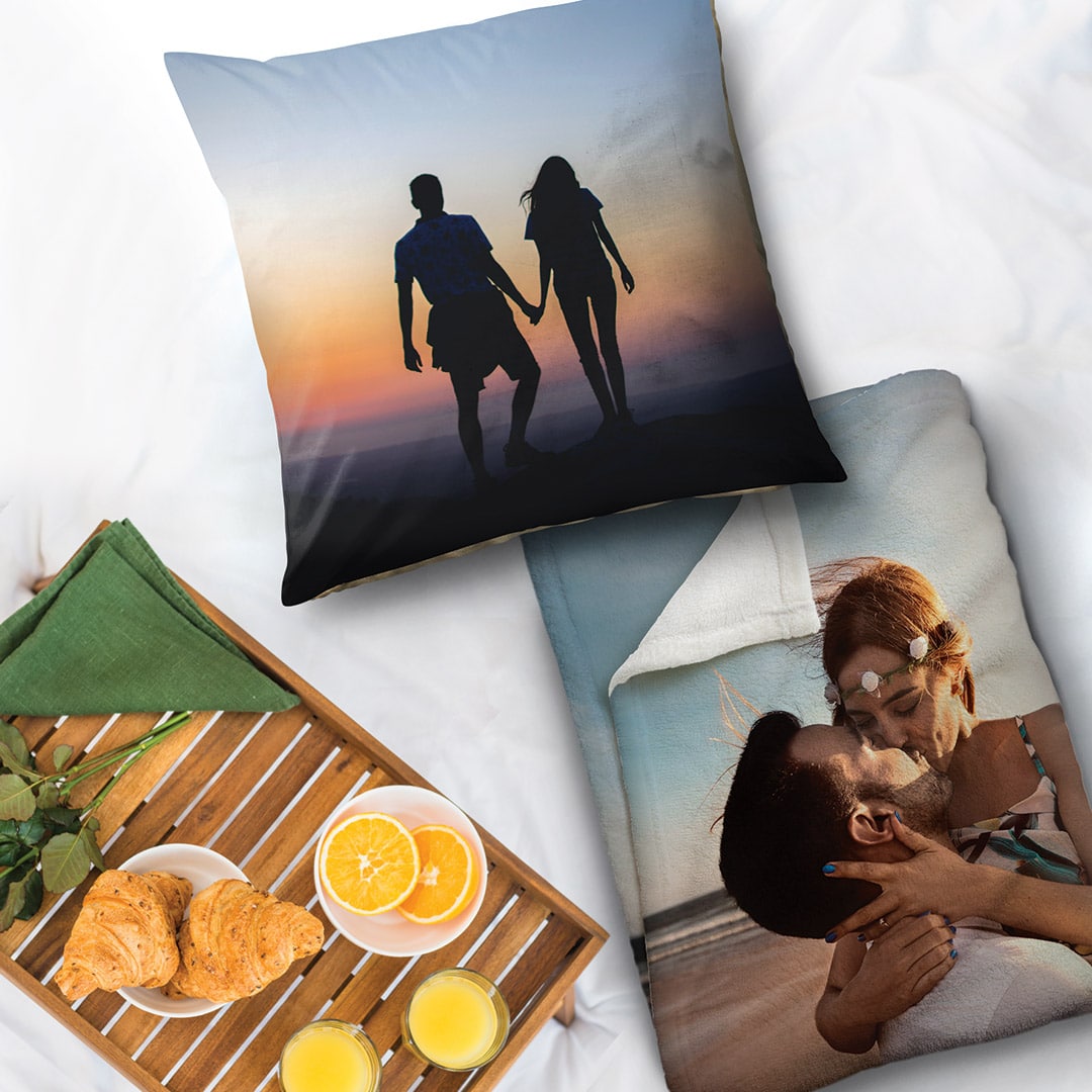 Photo cushion and blanket on bed with breakfast tray for Valentines