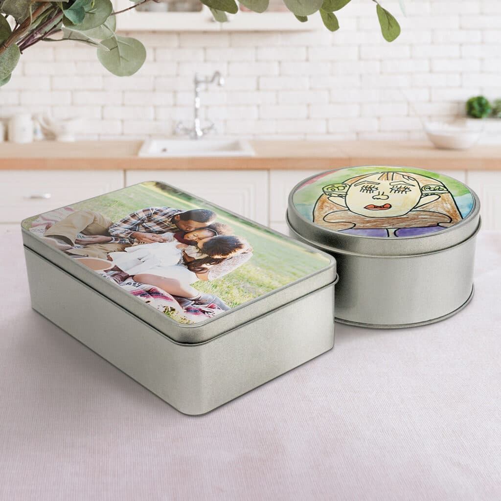 circular and rectangular tin with kids drawing on the top