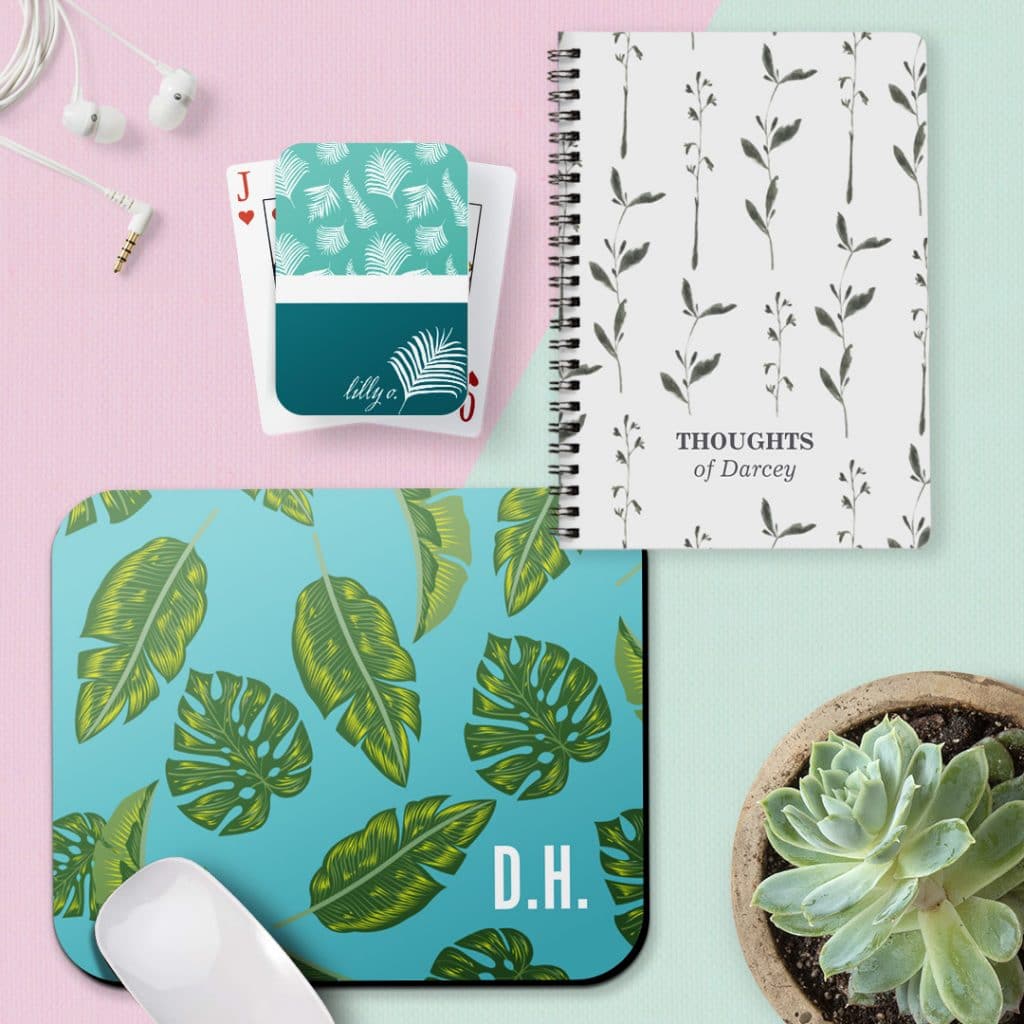 A personalised spiral notebook, set of playing cards and mousemat featuring leafy designs