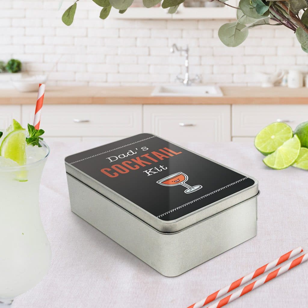 Rectangular personalised tin alongside cocktails in a kitchen