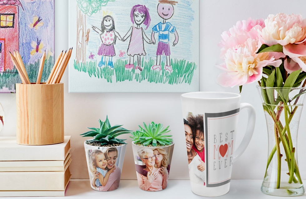 two potted plants and latte mug with photo tiles in background