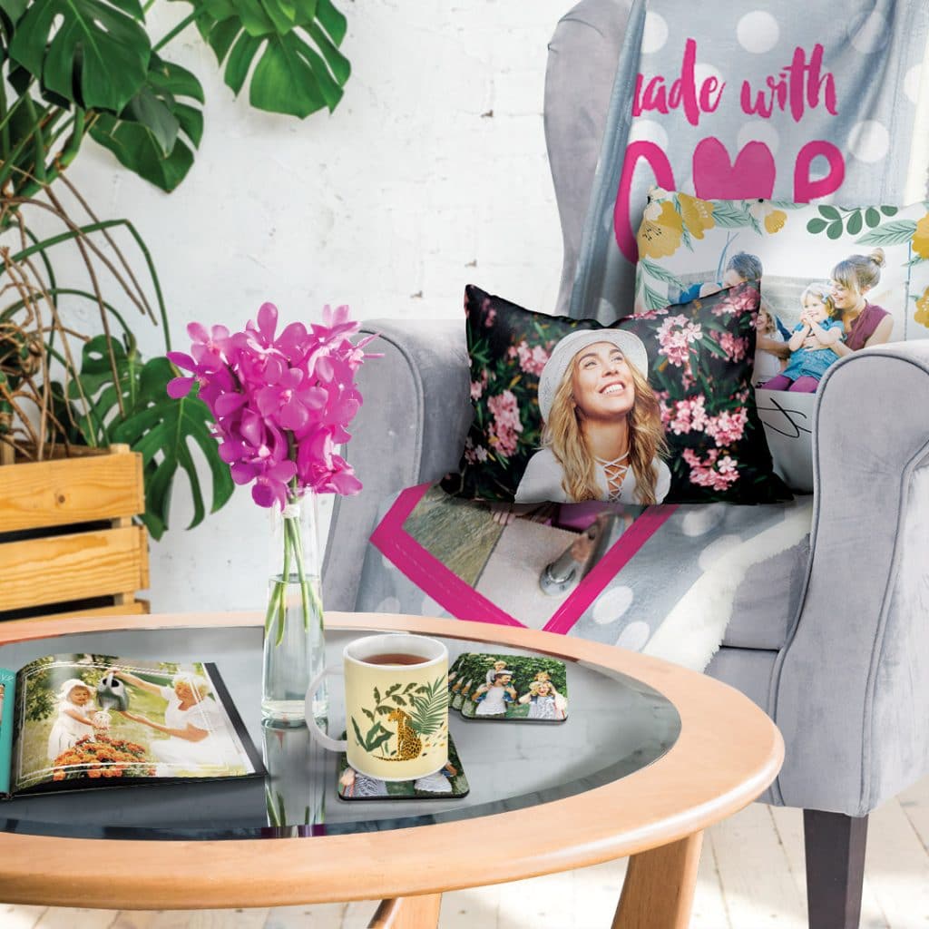 chair with cushion and blanket, table with photo book, mug and coasters are simple home decor updates