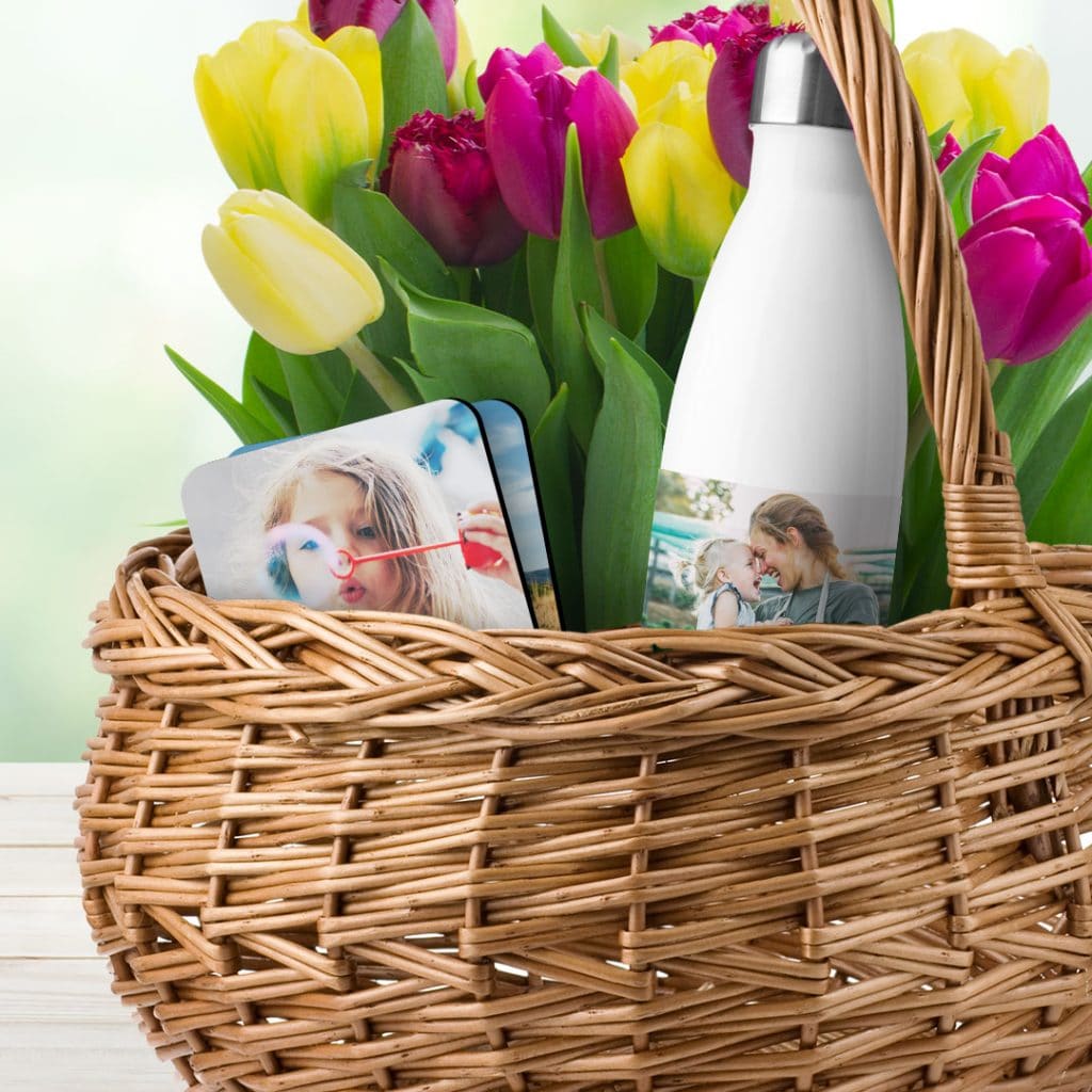 A spring basket containing tulips, a personalised water bottle and coasters