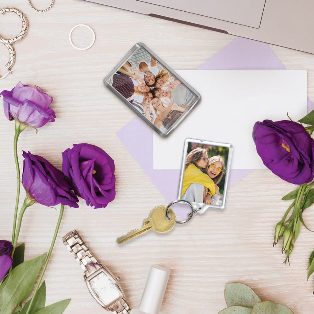 keyring and acrylic magnet on desk in front of computer and flowers