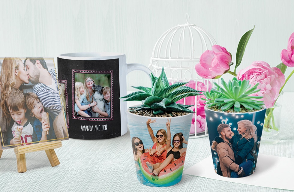 desk with two plant pots, a mug and a ceramic tile on stand