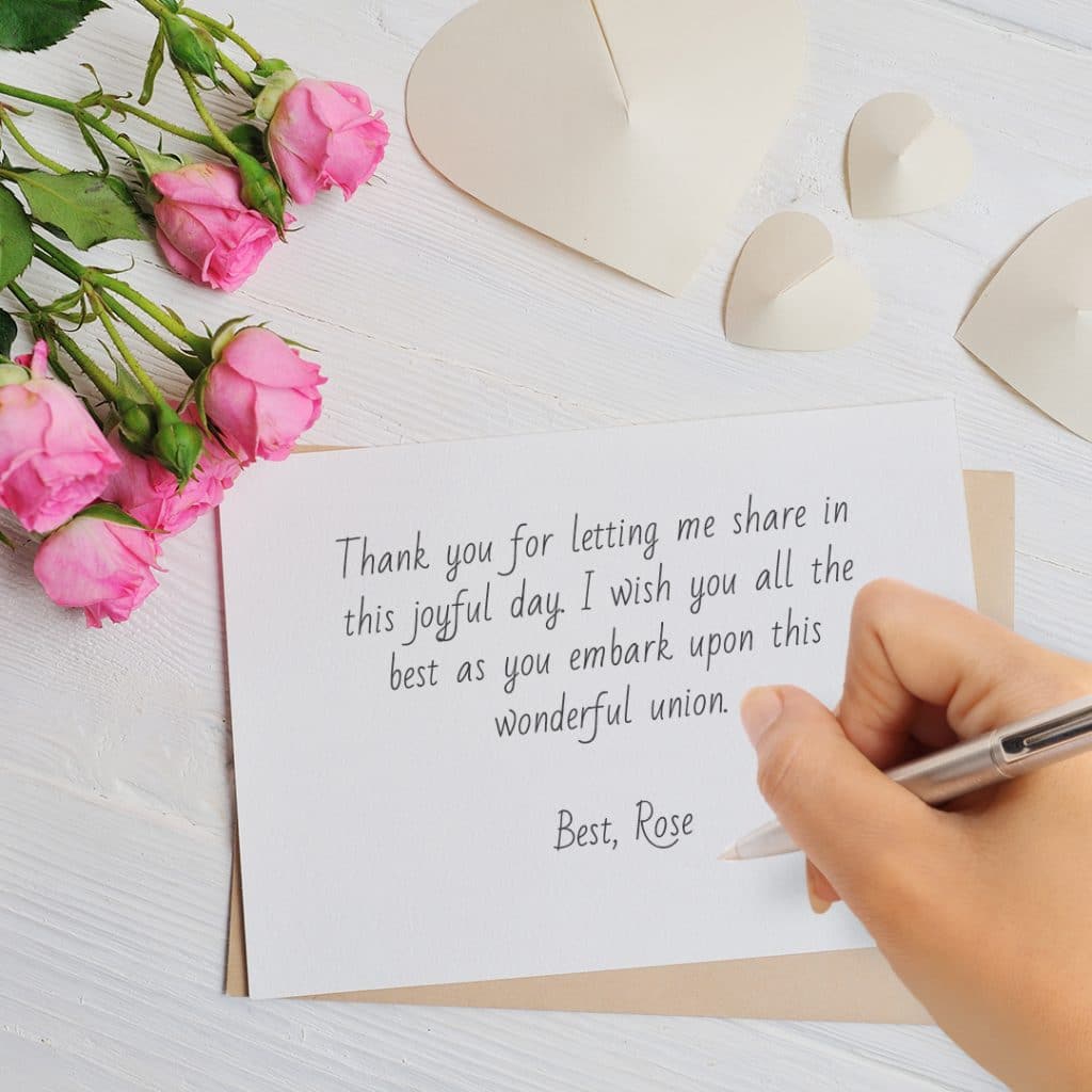 person writing formal wedding card message, with roses