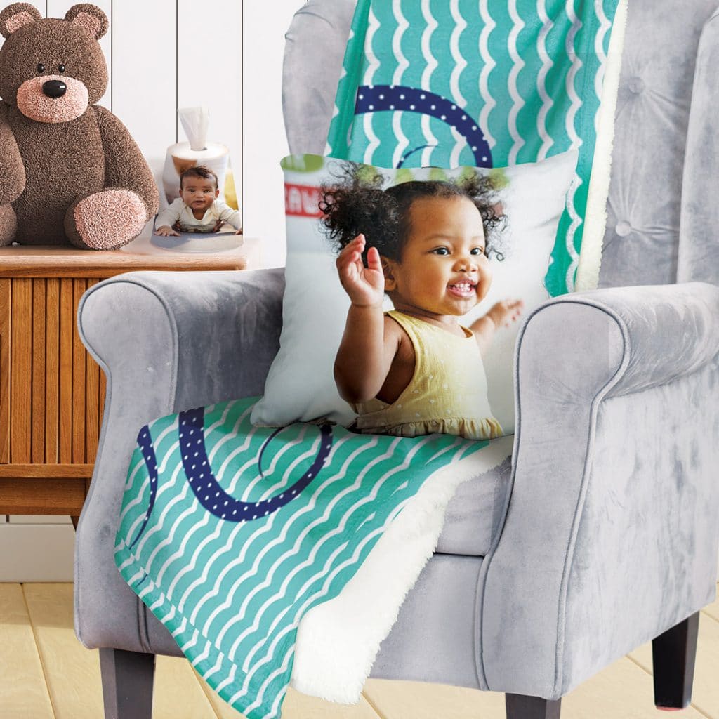 cushion and blanket on chair, a plant pot on the table used as a nappy bag dispenser