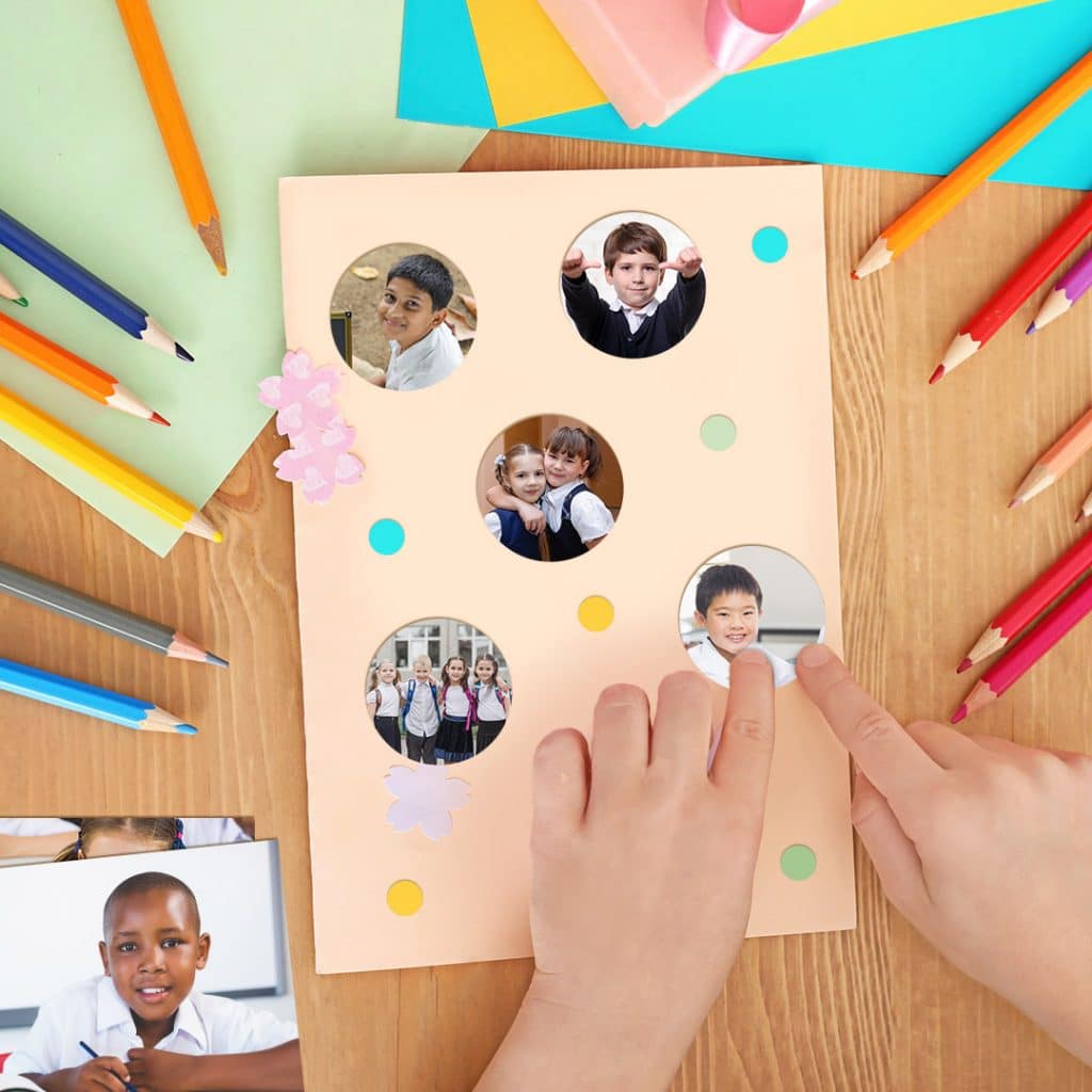 A child's hands crafting a homemade teacher thank you card using photo prints