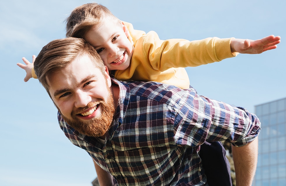 father carrying son on his back