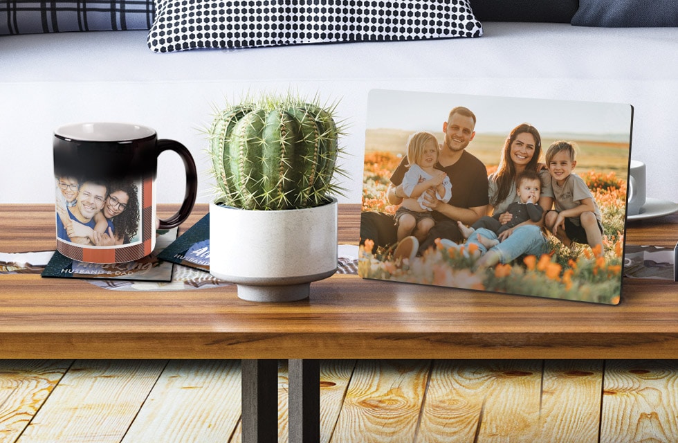 Selection of Father's Day gifts on coffee table showing wooden photo panel, magic mug and picture coasters