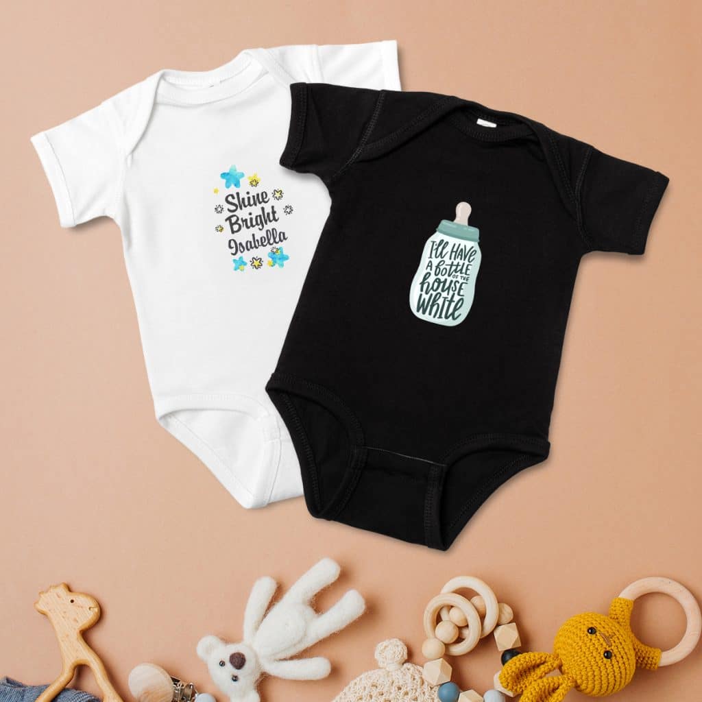 Flat lay of a white baby bodysuit and black baby bodysuit