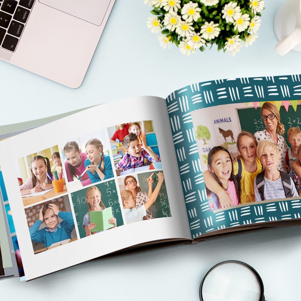 A thank you teacher photo book with collage images of children and their teacher presented on a light blue surface