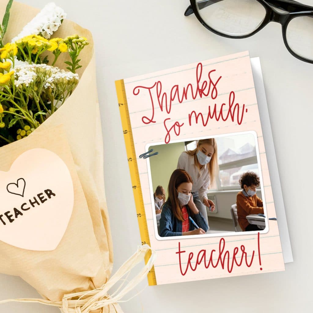 A thanks so much teacher card next to a lovely flower bouquet