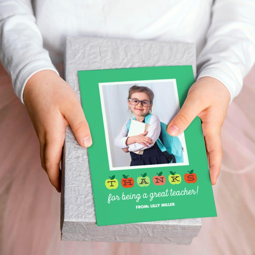 Child holding a present and a thanks for being a great teacher card