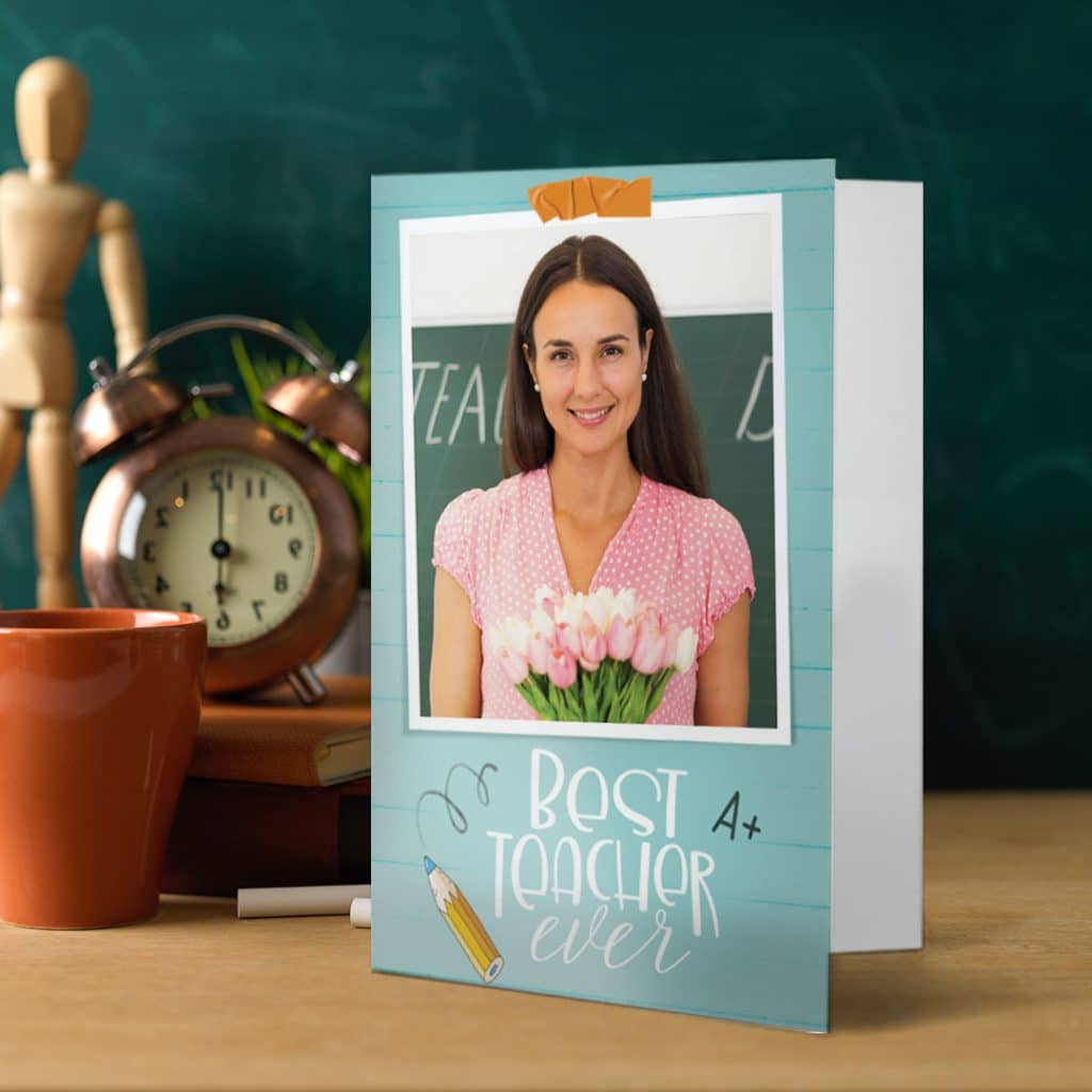 A best teacher card on a teacher's desk